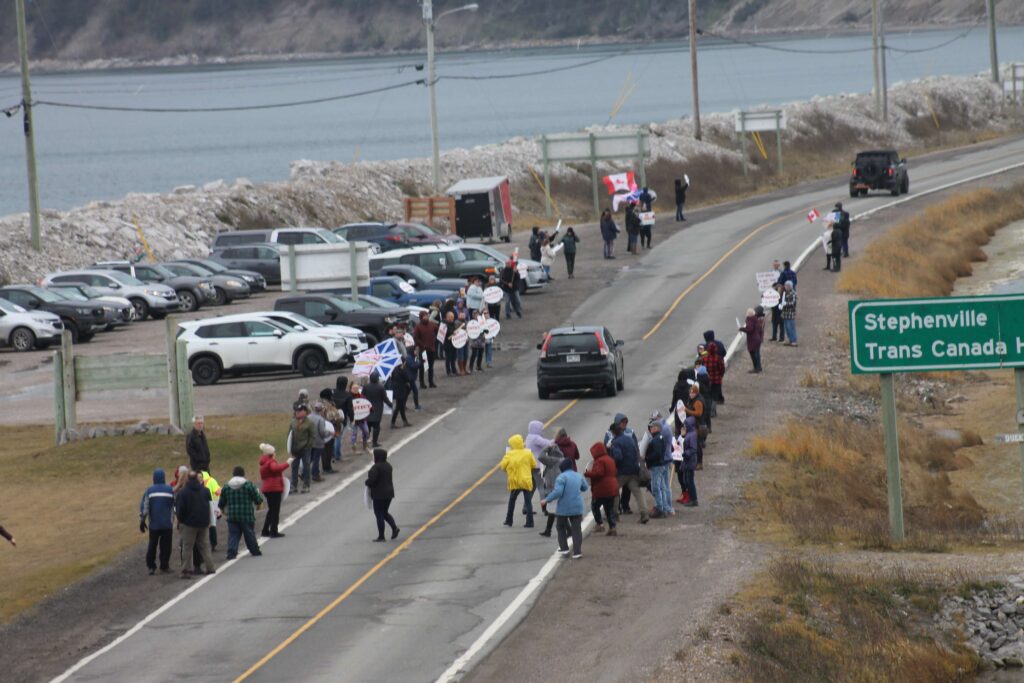 Community members of Port au Port stand united on the roadside, raising their voices and signs in peaceful protest to safeguard their forests, health, and local tourism from the proposed wind turbine project